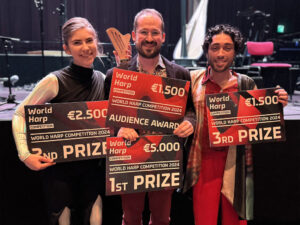 Amy Nam poses with two other harpists, all with giant prize awards in their hands.