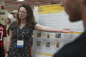 A student presents a poster about her work.