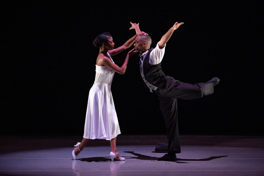 Two dancers look into each other's eyes while performing on stage