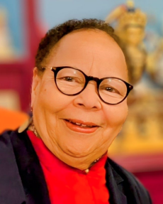 Headshot of Dr. Janice Willis wearing black-rimmed glasses and a red shirt.