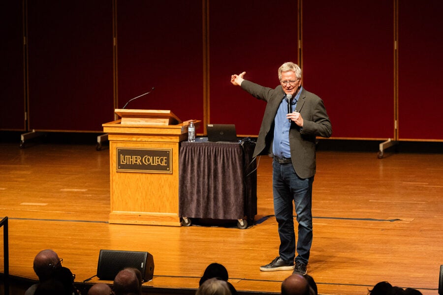 Rick Steves speaks on the stage of the Center for Faith and Life at Luther College.