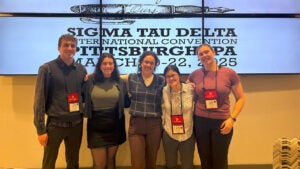Five college students smile for a photo at honor society convention