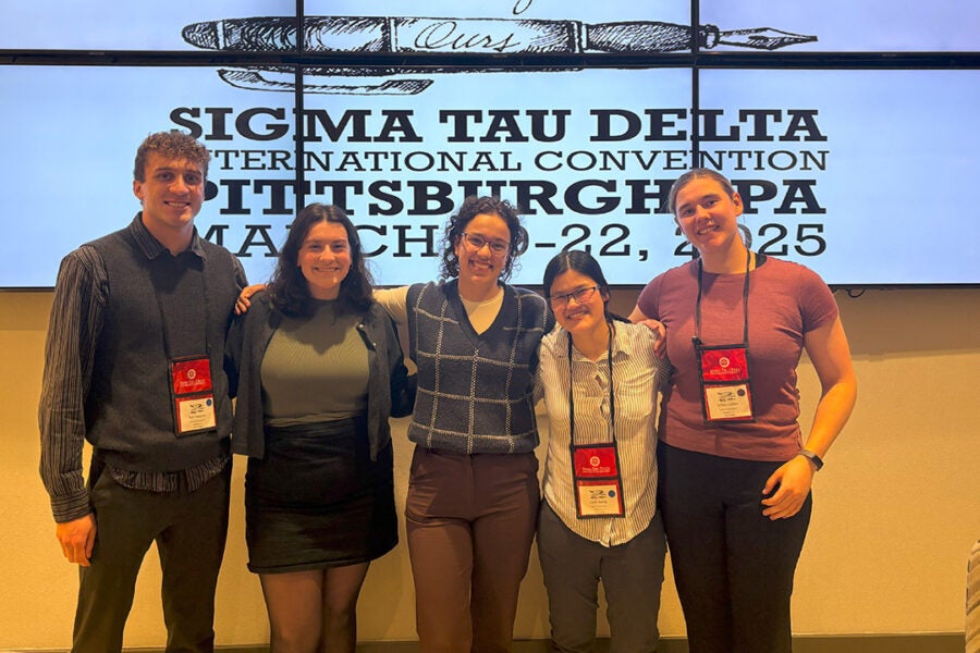 Five college students smile for a photo at honor society convention