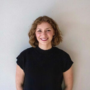 college student standing in front of white wall