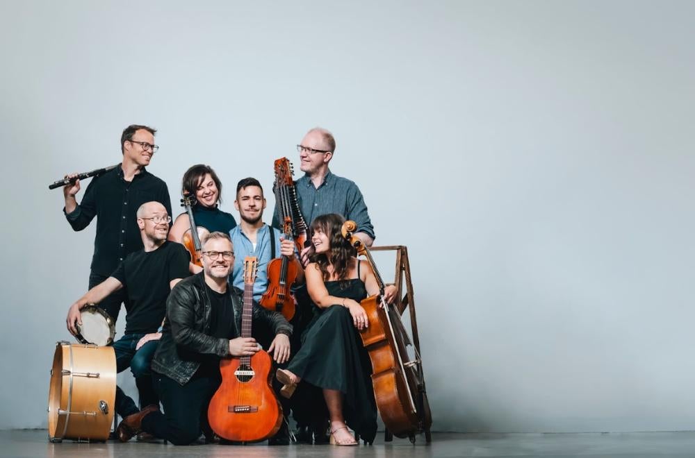 Members of jaerb and the OK Factor holdign tfront of a grey backdrop