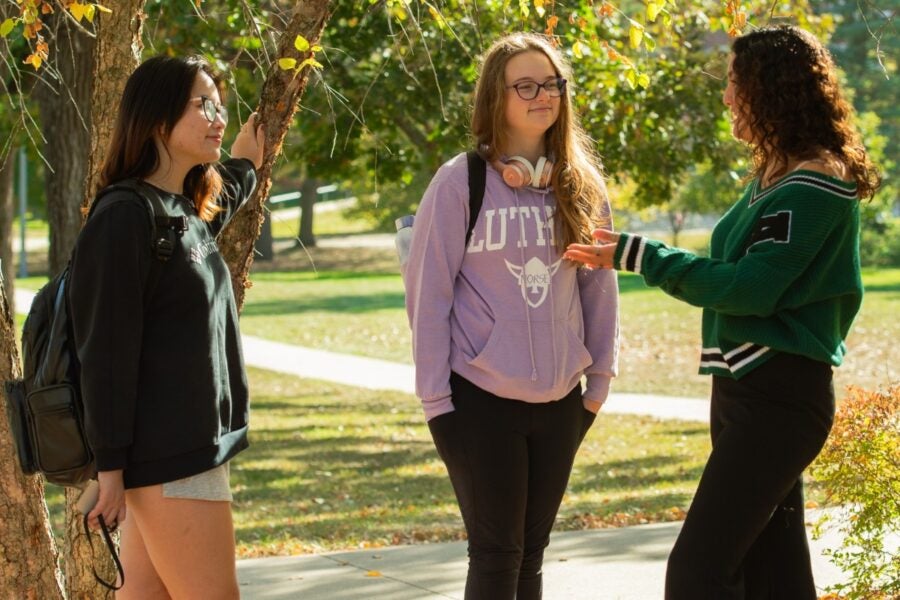 3 Students talking on campus.