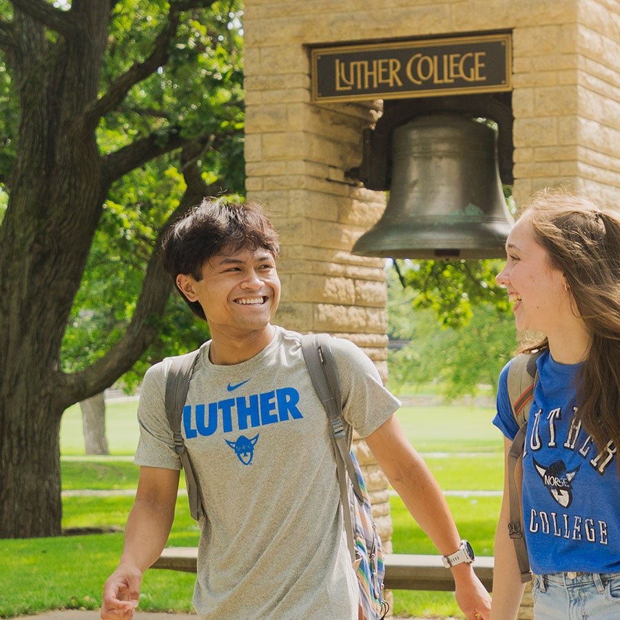 Two students walk past the Luther College bell