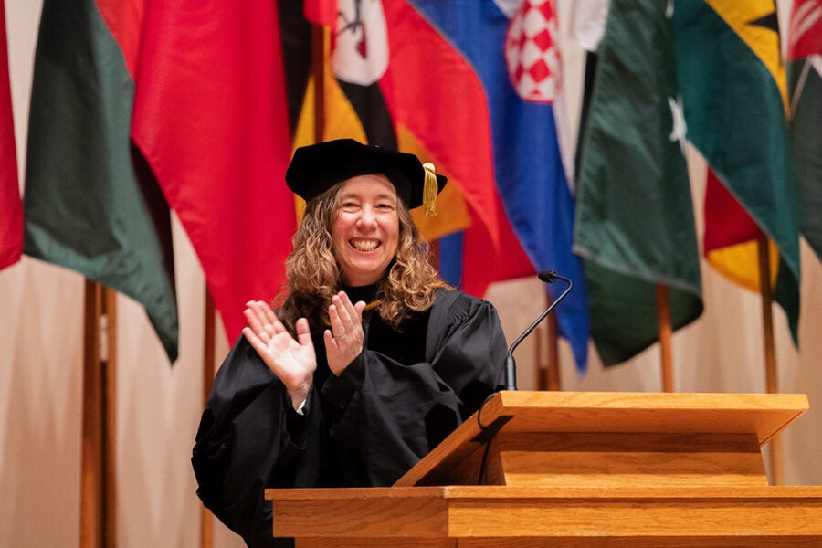 Luther College Provost Pam Bacon applauds at a ceremony.