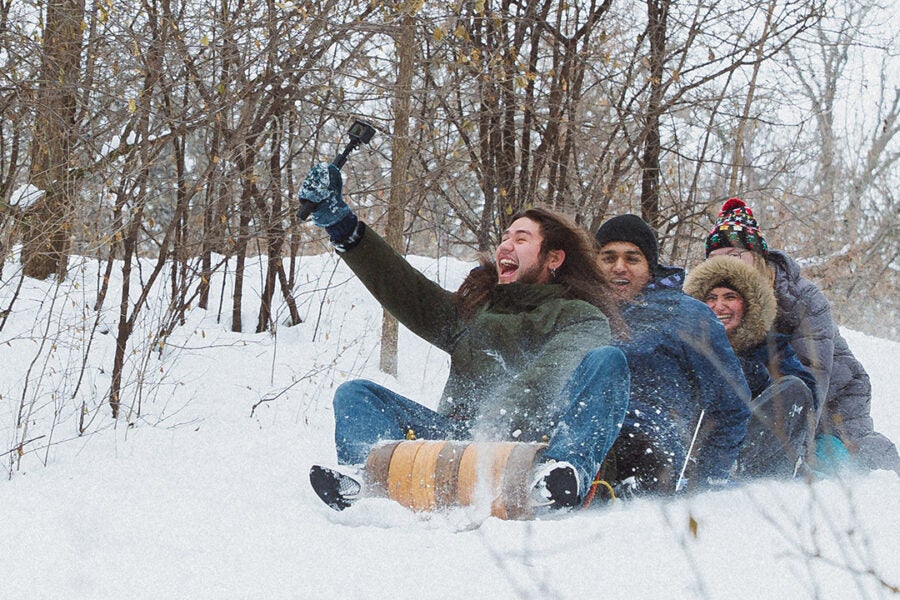 college students riding a sled