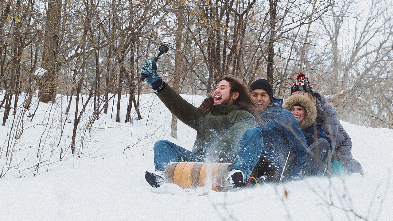 college students riding a sled