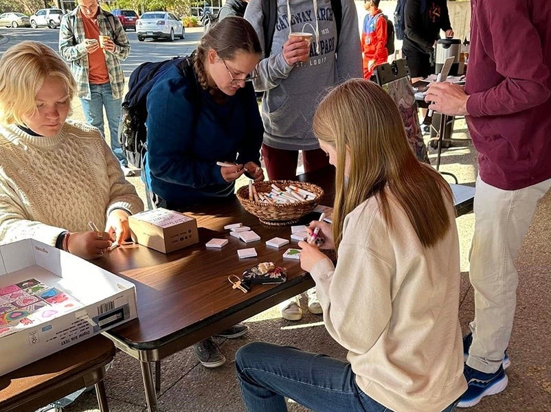 Students draw on canvases for Hearts of Peace collaborative project