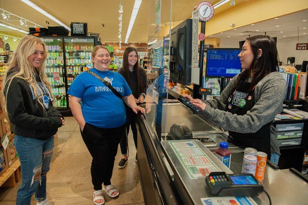 A group of students buying stuff at the checkout of the Oneota Food Co-op