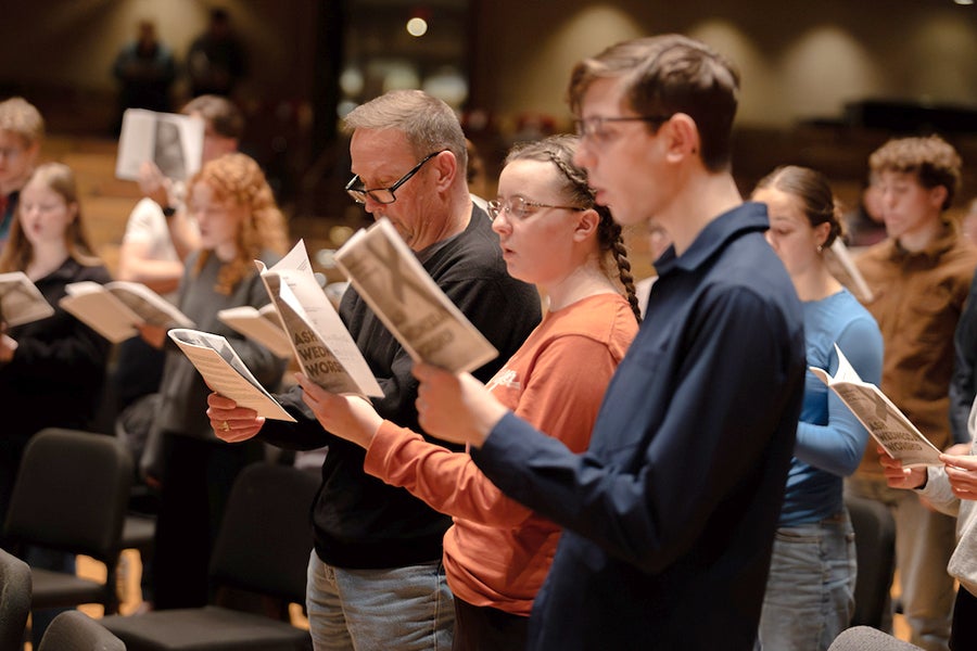 People singing off a song sheet in a worship service.