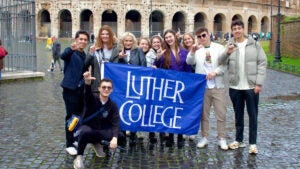 Luther College students stand with flag in Malta.