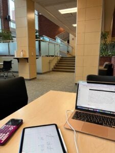 computer, tablet, and phone on a desk in a large atrium