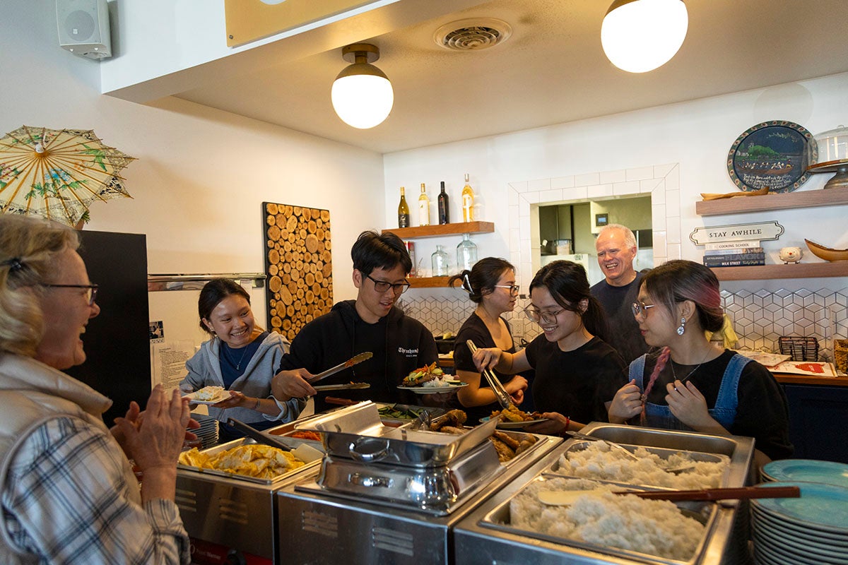 Students serve food at the Landing
