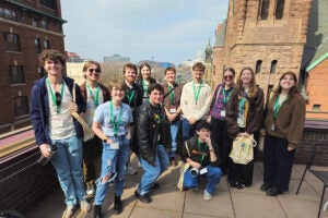 a group of 12 college students take a photo from the roof of Minnesota Public Radio offices in St. Paul, Minnesota