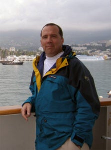 Luther College Professor Dan Davis is standing on a ship.