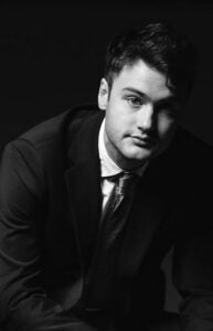 black and white photograph of person wearing a tie and suit jacket