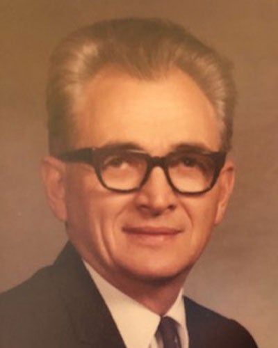 A head-on portrait of a man wearing glasses