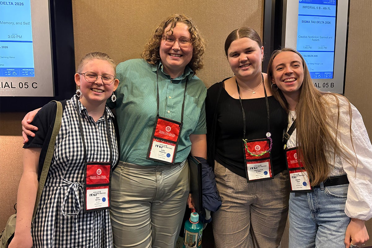 Four college students stand together for a group photo at an international convention