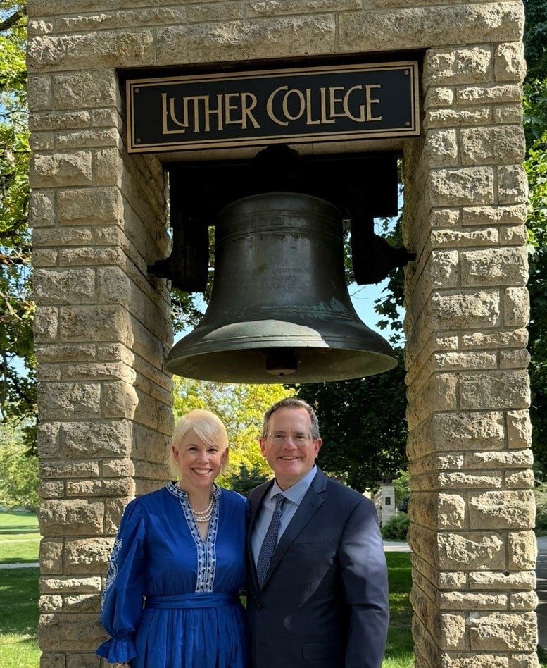 Shannon (Miller) Duval '95 and DeLane Duval standing in front of the Luther bell.