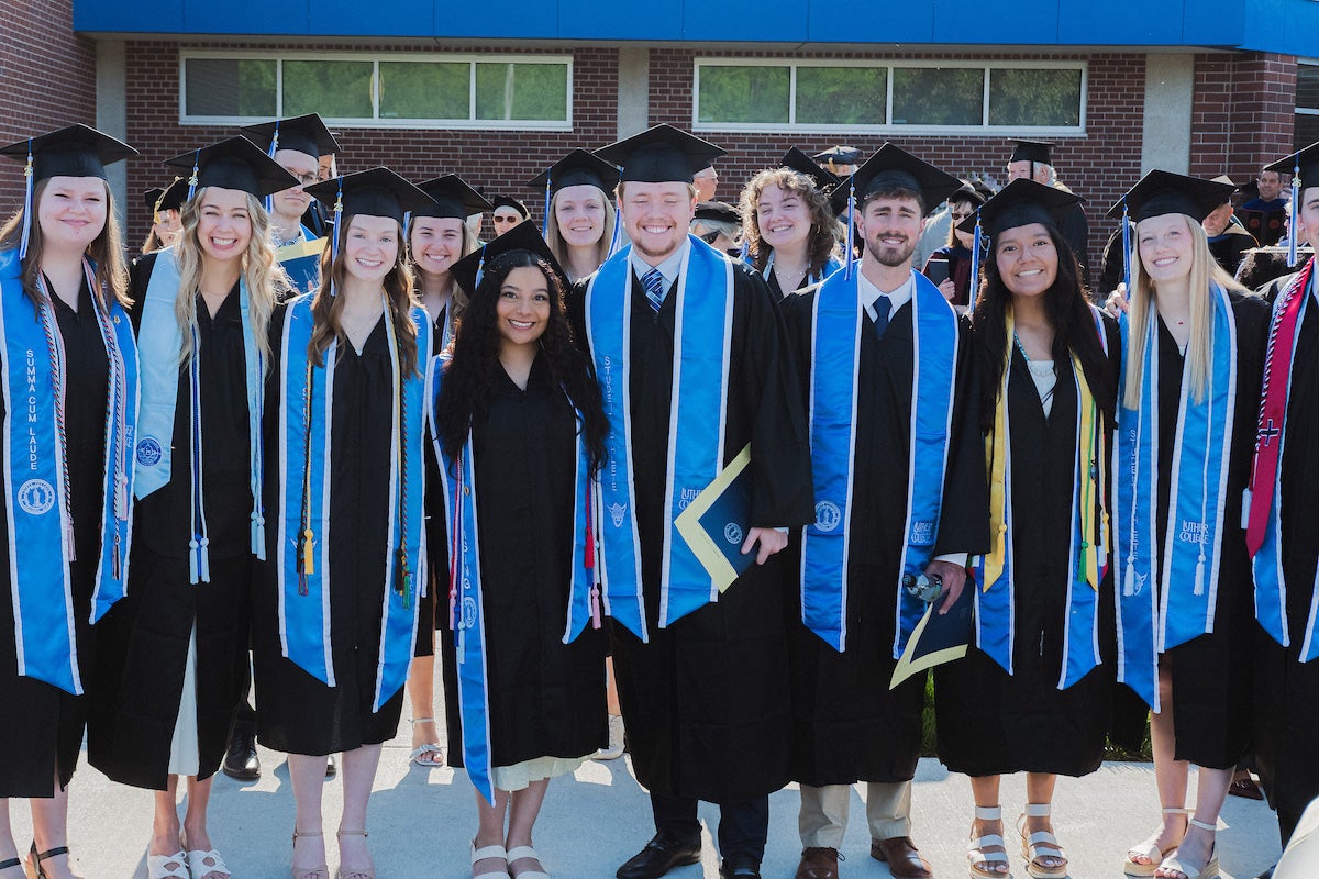 a row of college graduates stand for a photo