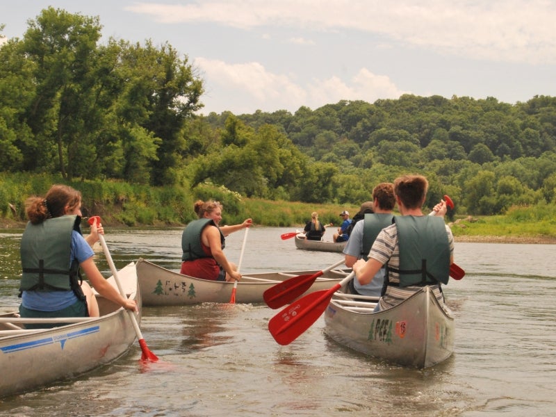 Group of people canoeing on a river.