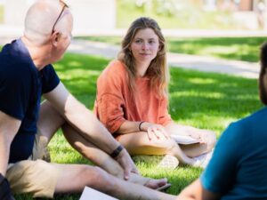 A group of people sitting outside talking