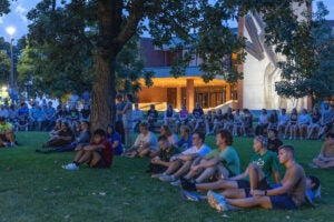 Luther College students sit on the lawn at Bentdahl Commons.