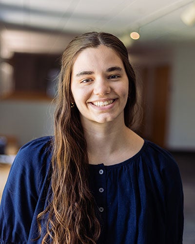 A smiling young woman in a blue shirt