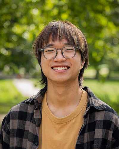 A smiling man in a plaid shirt