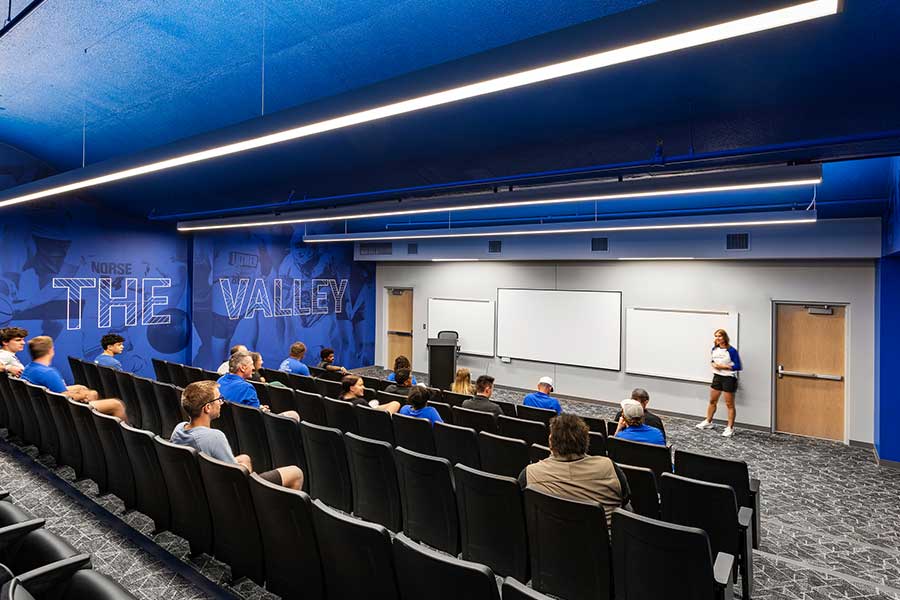 A big room with large whiteboards at the front and several rows of seating