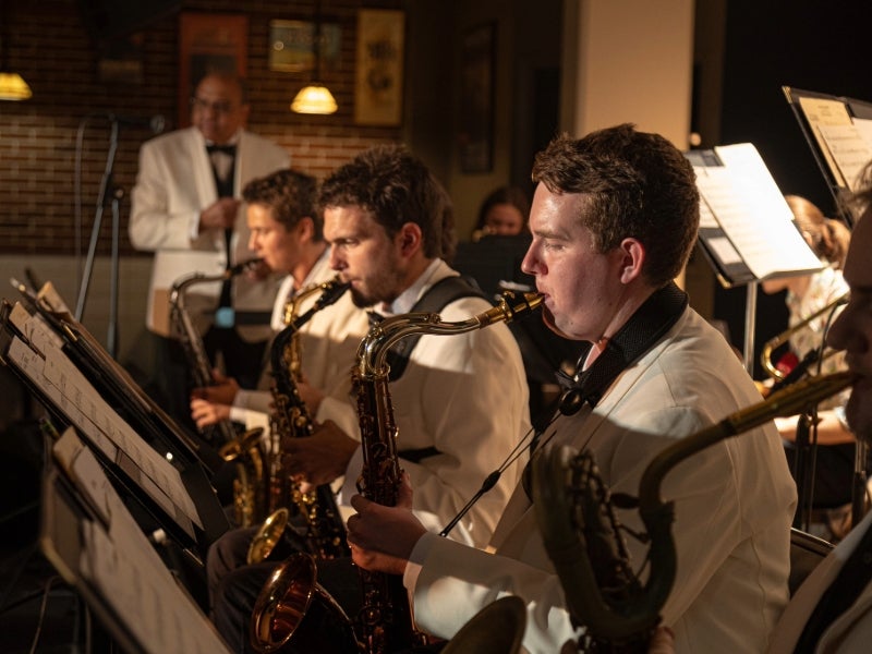 Saxophonists play in a jazz ensemble