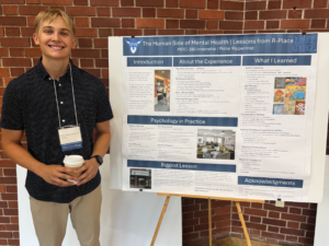 student standing in front of psychology project