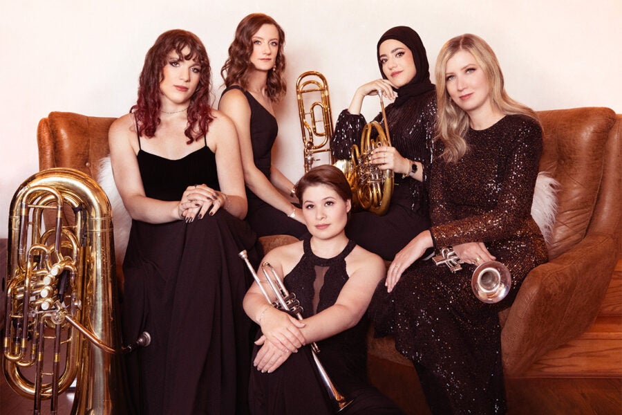 Five women play brass instruments